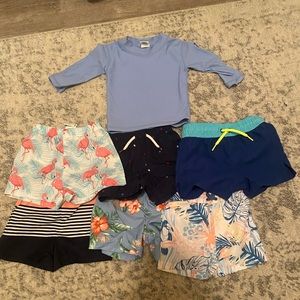 Assorted baby boys swim trunks and rash guard.